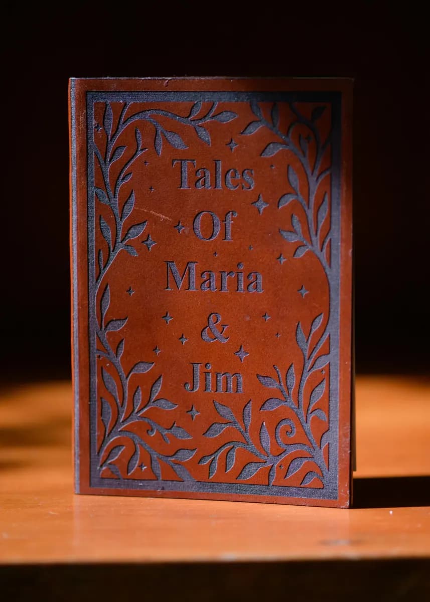 Leather-bound book invitation on a vintage glass tray